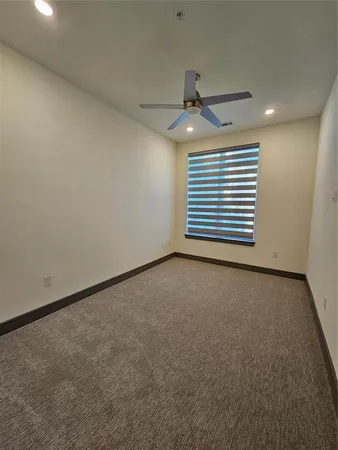 an empty room with a ceiling fan and a window