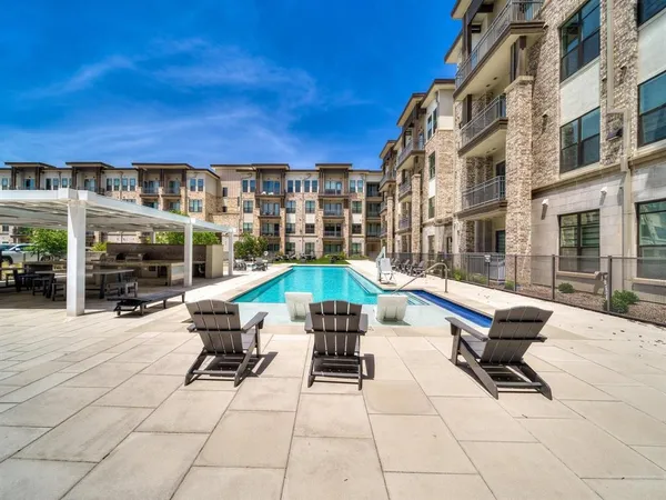 a view of a chairs and table in the patio with a barbeque grill