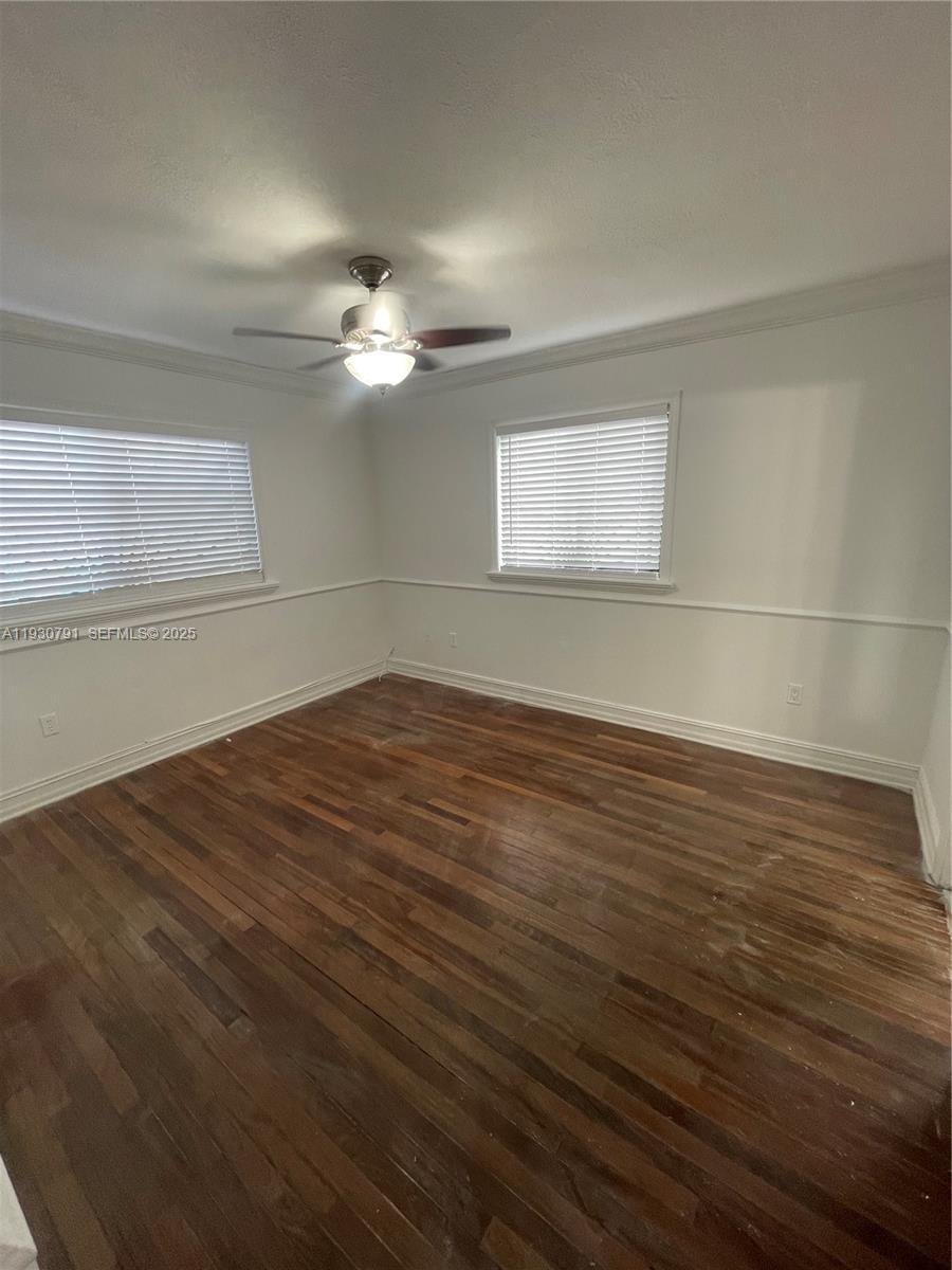 6450 West 27th Way, Unit 101 Hialeah, FL 33016 - Photo 5 of 11 a view of a room with wooden floor and a ceiling fan