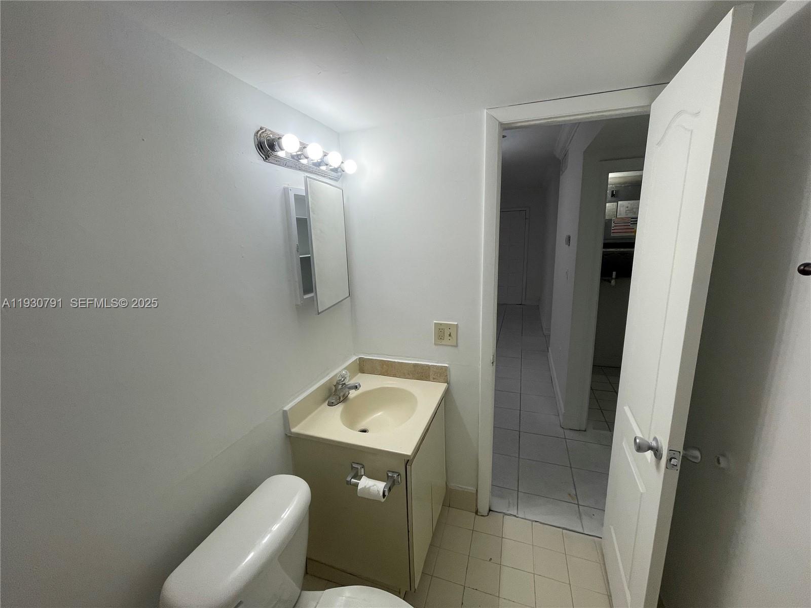 6450 West 27th Way, Unit 101 Hialeah, FL 33016 - Photo 6 of 11 a bathroom with a toilet sink and mirror