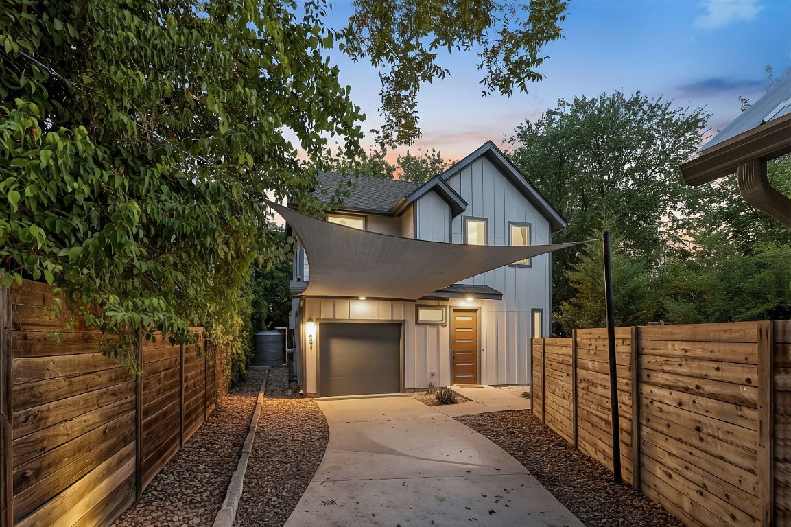 A contemporary two-story home offering rare privacy in one of Austin’s most vibrant central neighborhoods, featuring sleek modern architecture, a shaded driveway, and inviting curb appeal surrounded by lush greenery.