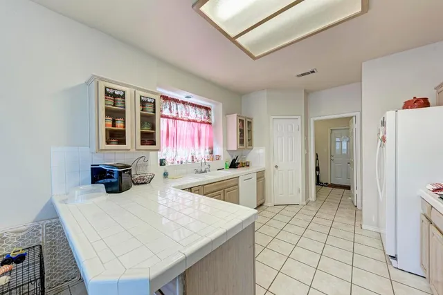 a kitchen with a sink a refrigerator and cabinets