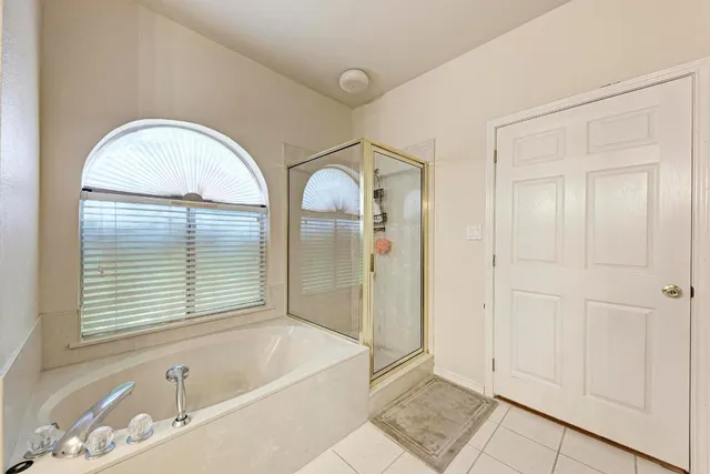a bathroom with a tub a sink and a window