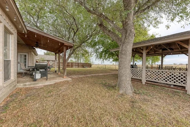 a view of a yard with wooden fence