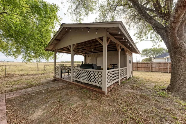 a view of a wooden house with a small yard and wooden fence