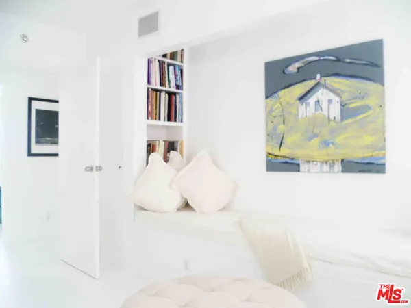 a bedroom with a bed and a painting on the wall