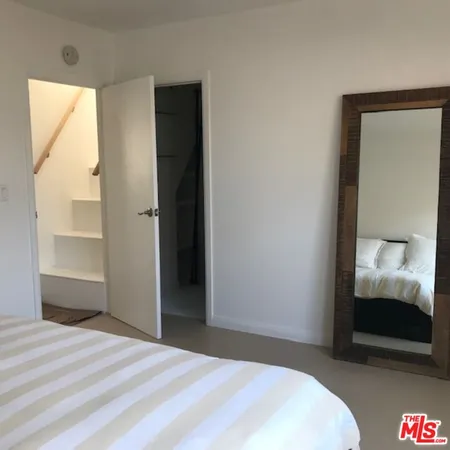 a bedroom with a bed and a mirror