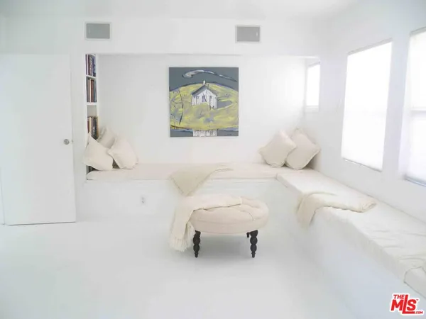 a bedroom with a bed and a painting on the wall