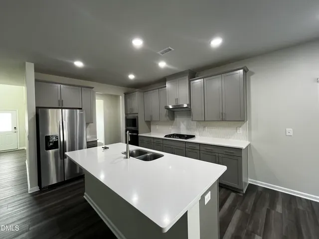 a kitchen with a appliances a sink and a refrigerator