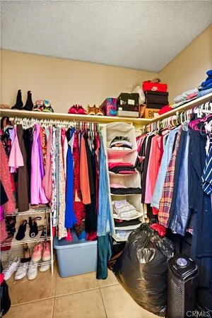 a view of walk in closet with clothes and shoes