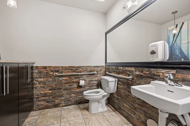 a bathroom with a toilet sink and mirror