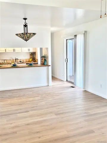 a living room with stainless steel appliances kitchen island granite countertop a sink and cabinets