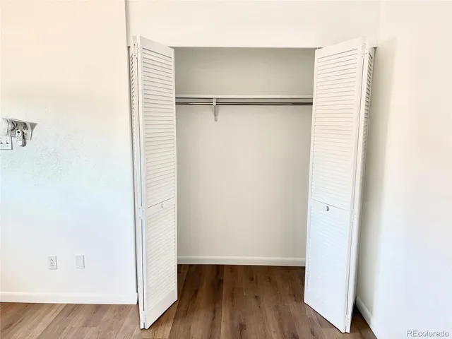 an empty room with wooden floor and a window