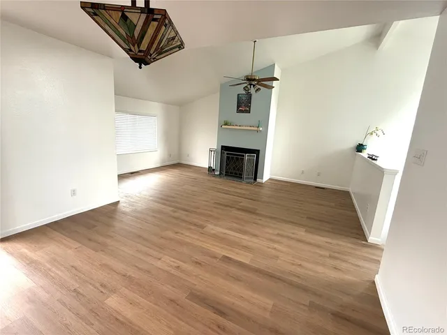 an empty room with windows and fireplace