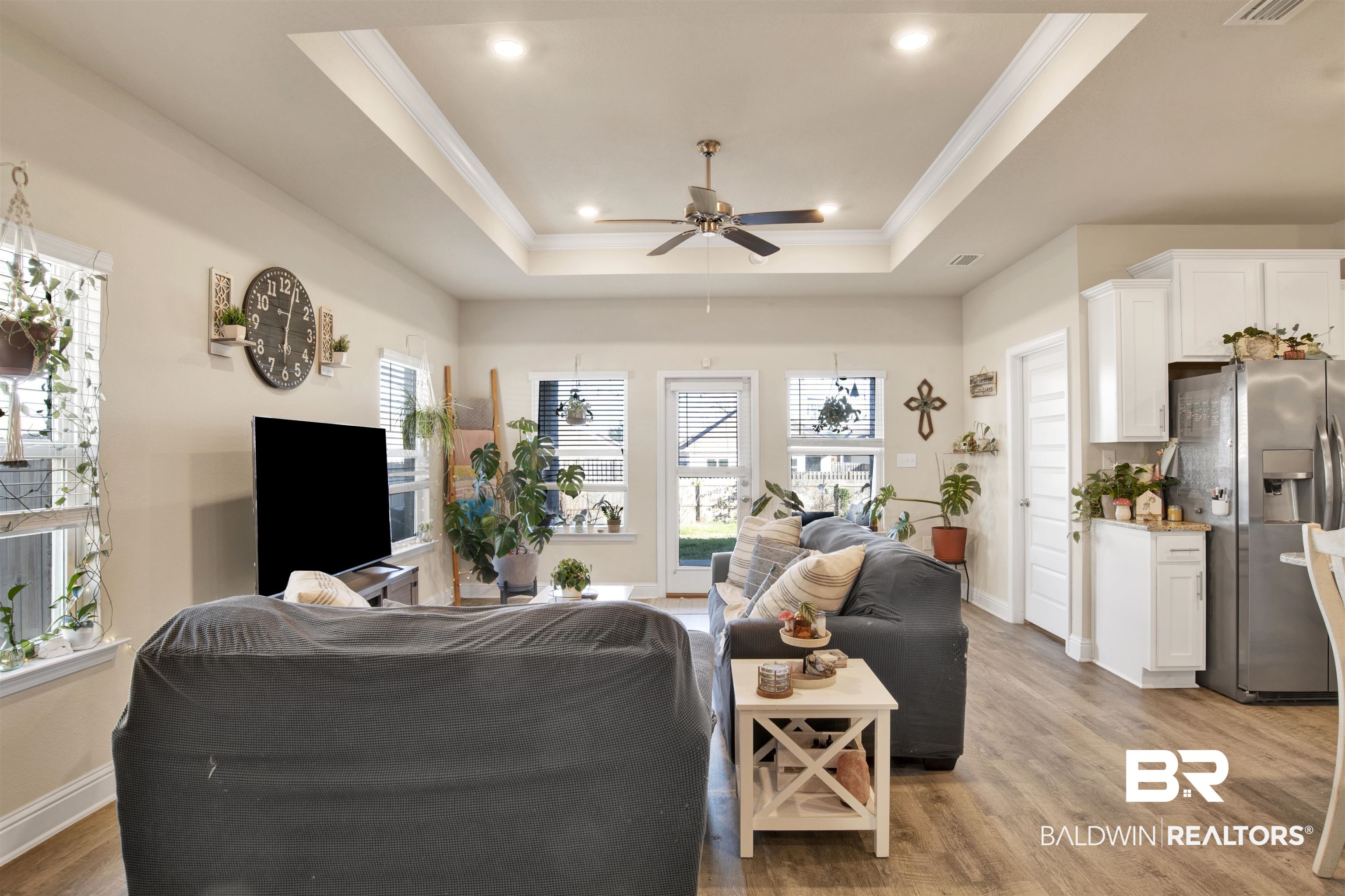 9622 Volterra Avenue Daphne, AL 36526 - Photo 12 of 31 Living room with a tray ceiling, ceiling fan, wood-type flooring, and ornamental molding