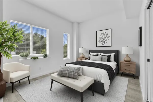 a bedroom with bed couch and window