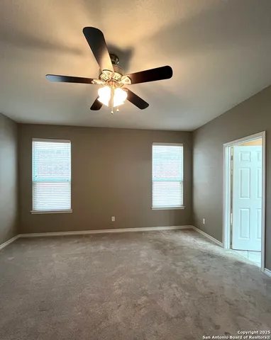 en empty room with windows and fan