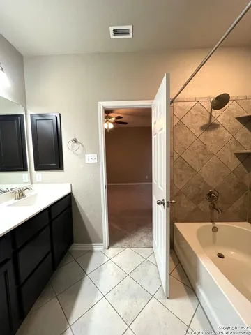 a bathroom with a bathtub sink and mirror