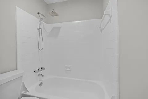 a bathroom with a bath tub with a shower
