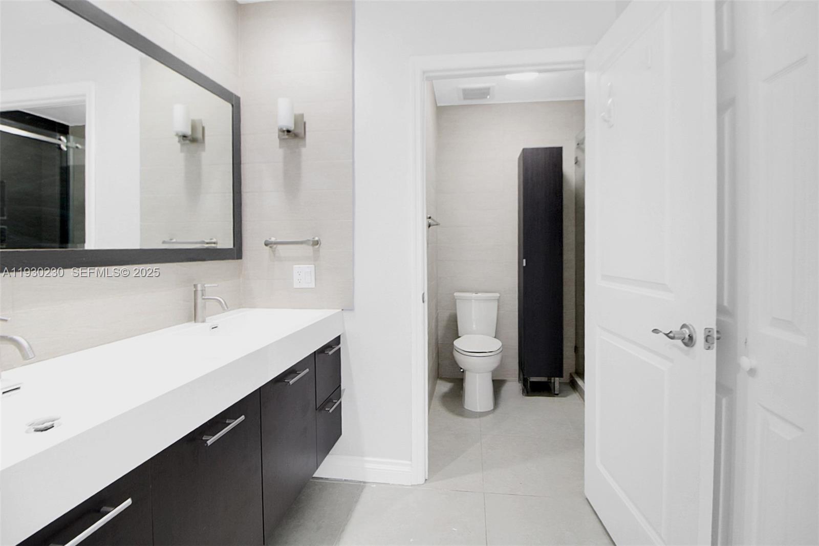 1022 Southwest 138th Place Miami, FL 33184 - Photo 25 of 39 a bathroom with a sink and a mirror