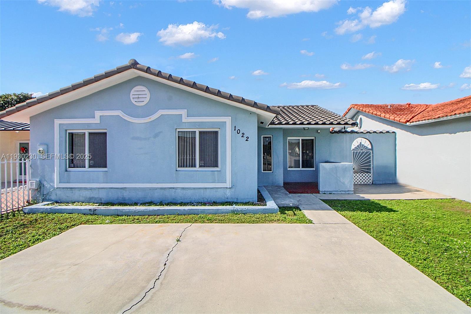 1022 Southwest 138th Place Miami, FL 33184 - Photo 6 of 39 a front view of a house with a yard and garage