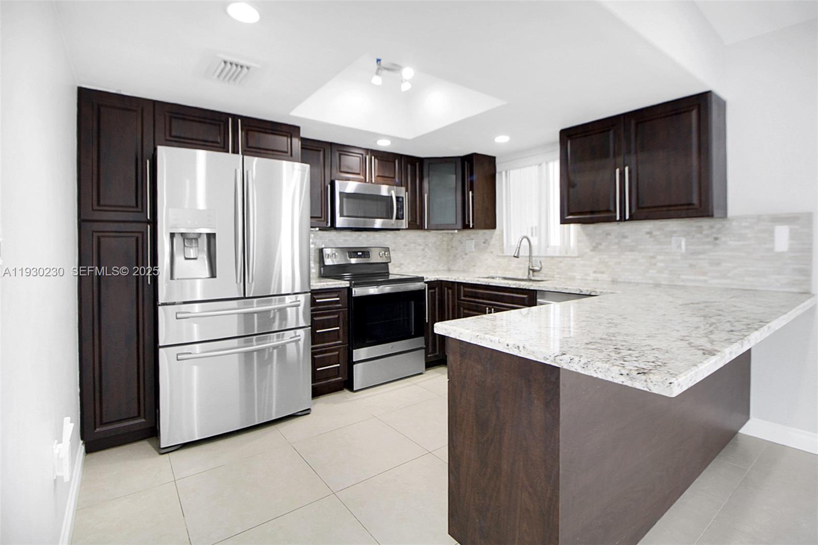 1022 Southwest 138th Place Miami, FL 33184 - Photo 8 of 39 a kitchen with stainless steel appliances granite countertop a refrigerator and a sink