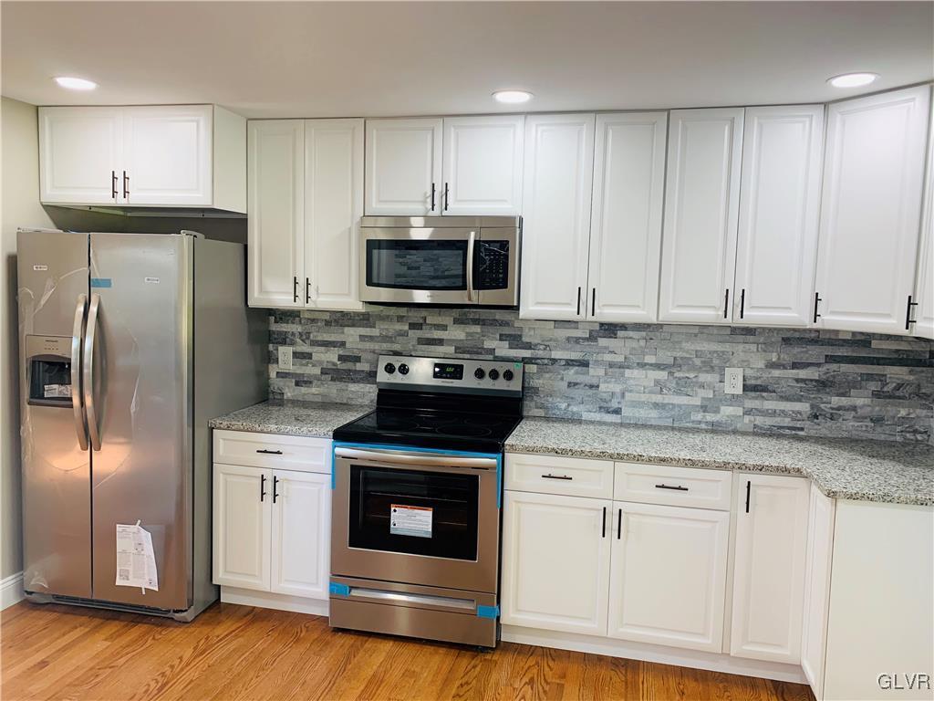 560 Knauss Road Nazareth, PA 18064 - Photo 7 of 25 a kitchen with stainless steel appliances granite countertop a stove a refrigerator and a microwave