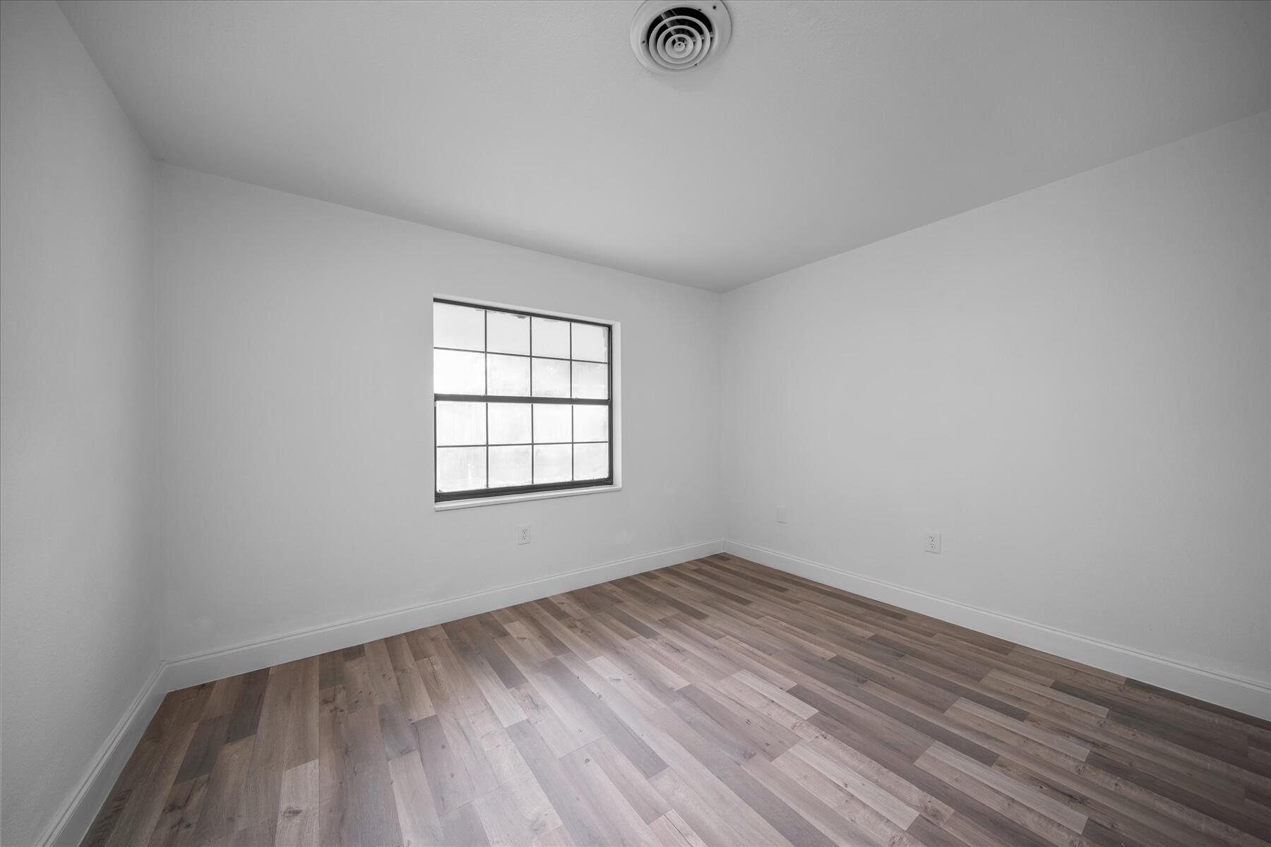 300 East Fee Avenue Melbourne, FL 32901 - Photo 17 of 27 an empty room with wooden floor and windows