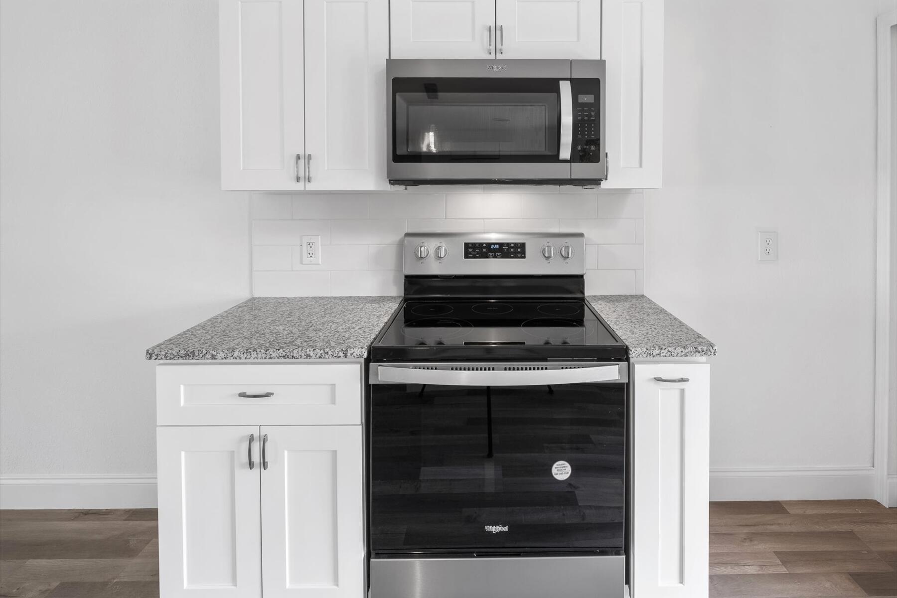 300 East Fee Avenue Melbourne, FL 32901 - Photo 25 of 27 a kitchen with stainless steel appliances granite countertop a stove and a microwave