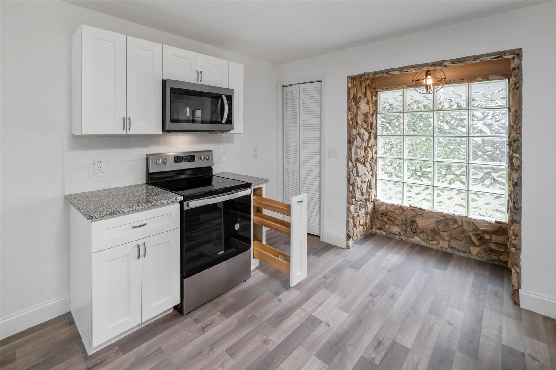 300 East Fee Avenue Melbourne, FL 32901 - Photo 7 of 27 a kitchen with a stove a sink and a microwave