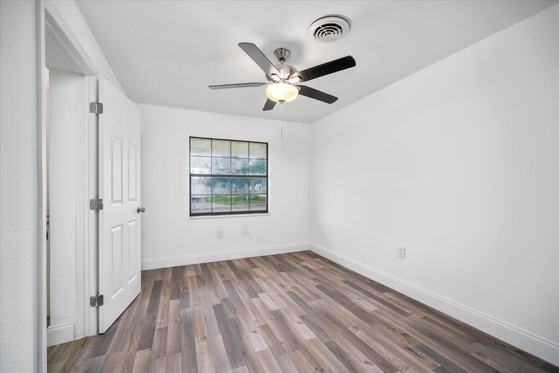 300 East Fee Avenue Melbourne, FL 32901 - Photo 10 of 27 wooden floor in an empty room with a window