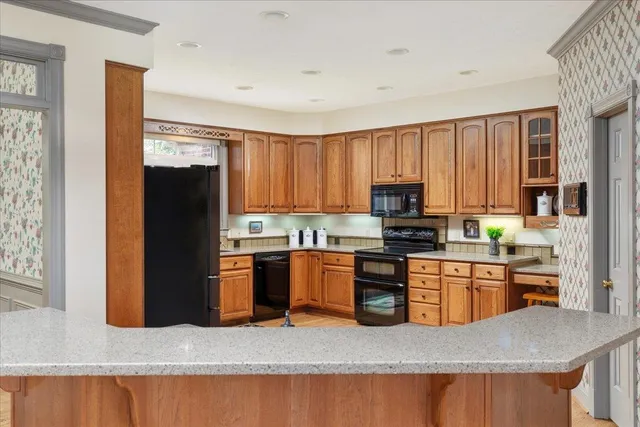 a kitchen with stainless steel appliances granite countertop wooden cabinets a sink and a stove