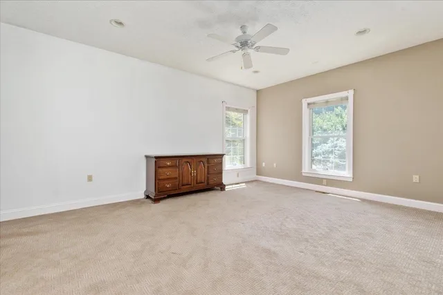 an empty room with a window and a ceiling fan