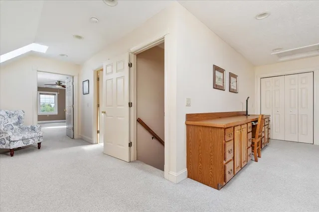 a living room with furniture a flat screen tv and kitchen view
