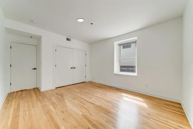 a view of empty room with wooden floor