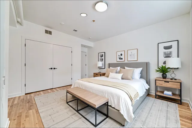 a bedroom with a bed and a painting on the wall