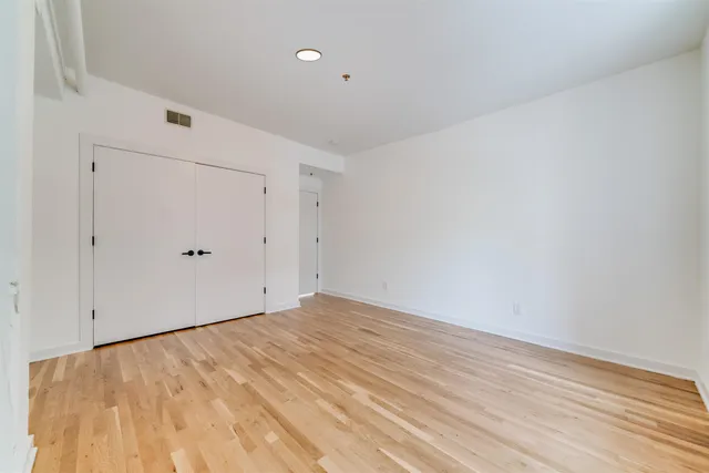 a view of empty room with wooden floor
