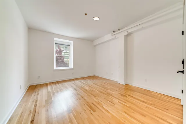 wooden floor in an empty room with a window