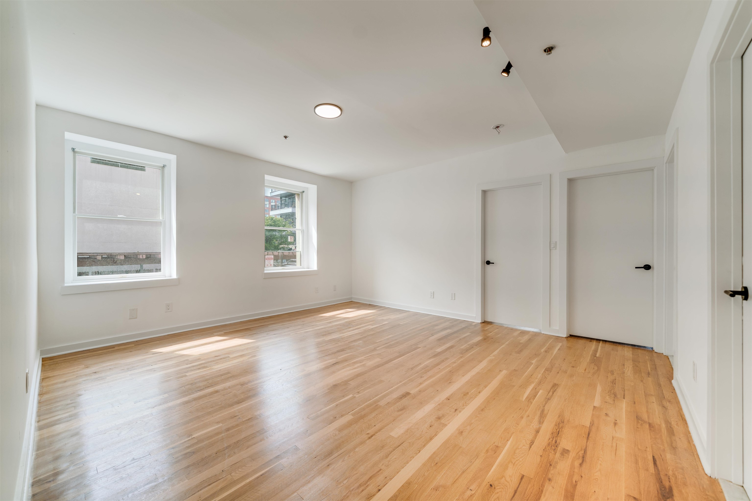 716 Madison Street, Unit 110 Hoboken, NJ 07030 - Photo 7 of 15 a view of empty room with wooden floor and fan