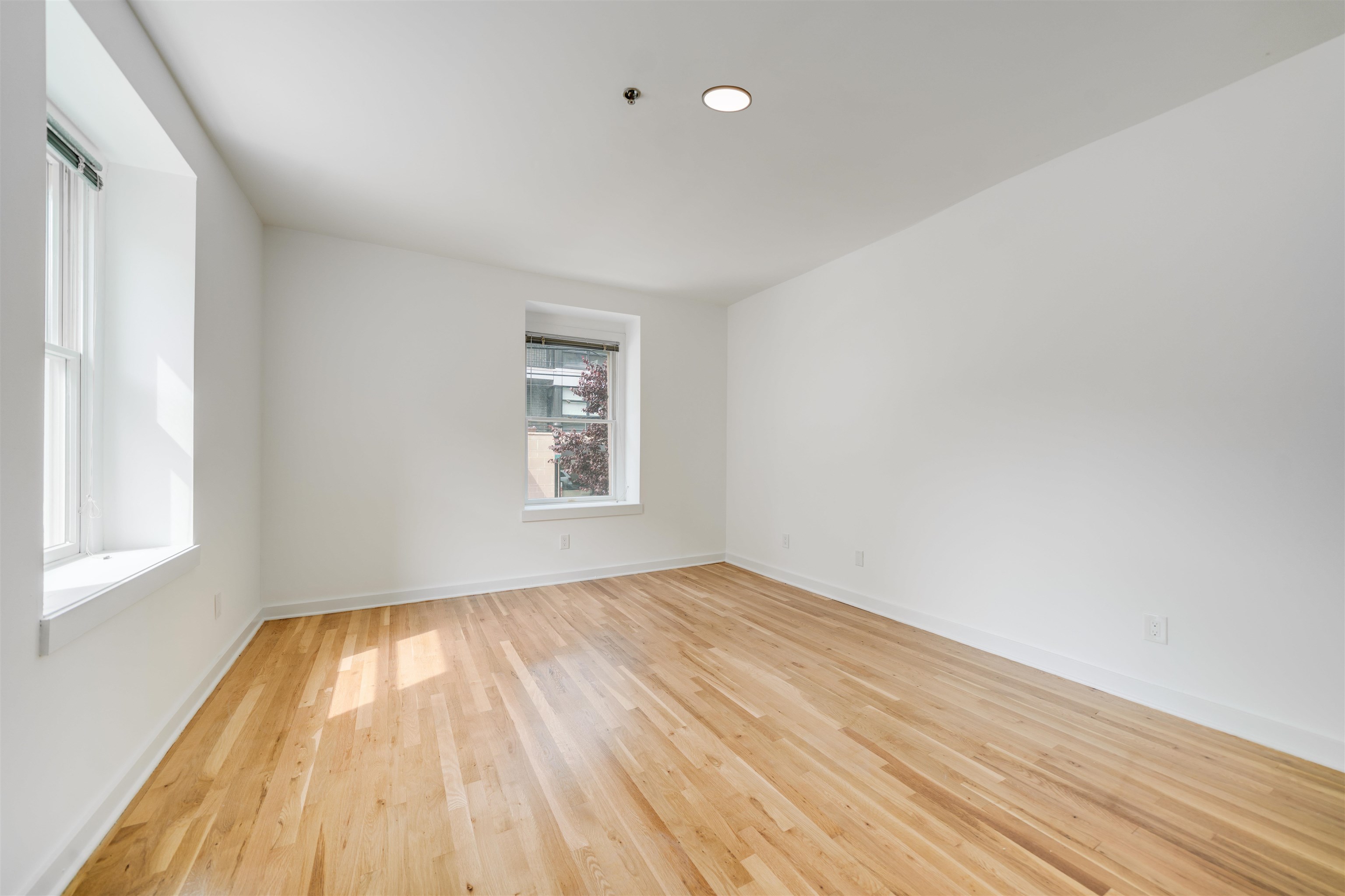 716 Madison Street, Unit 110 Hoboken, NJ 07030 - Photo 9 of 15 an empty room with wooden floor and windows