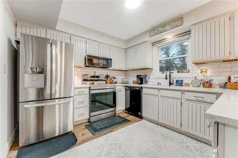 a kitchen with a sink window and cabinets
