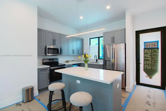 a kitchen with stainless steel appliances granite countertop a sink a stove a refrigerator a microwave oven with a dining table and chairs