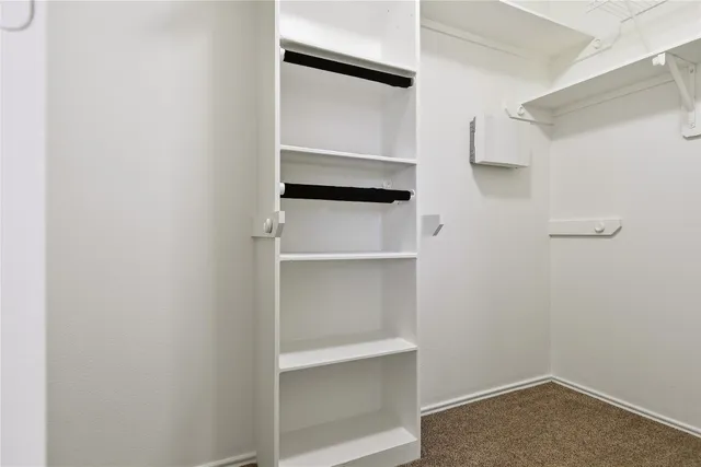 a view of walk in closet with empty racks