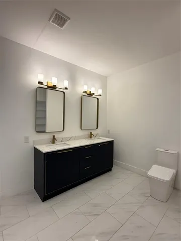 a spacious bathroom with a toilet sink and mirror
