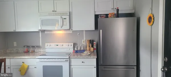 a white refrigerator freezer and a stove sitting inside of a kitchen