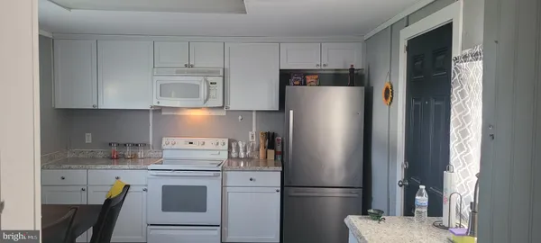 a kitchen with stainless steel appliances granite countertop a refrigerator sink and stove