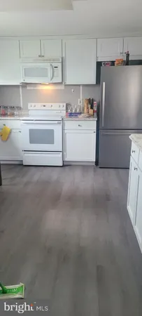 a kitchen with stainless steel appliances granite countertop a refrigerator a stove and a sink