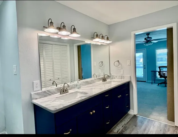 a bathroom with a double vanity sink mirror and bathtub