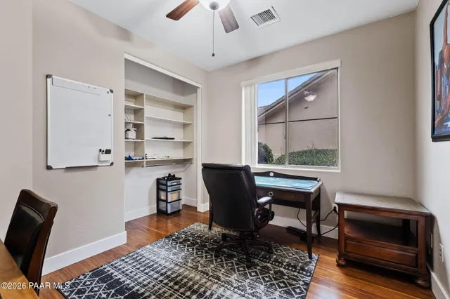 a view of a workspace with furniture and a window