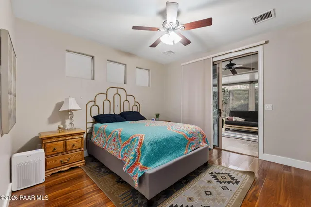a bedroom with a bed next to a window and a chandelier